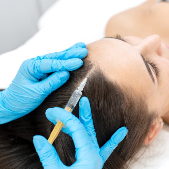 Close-up, the beautician makes injections of vitamins into the scalp for strengthening the hair